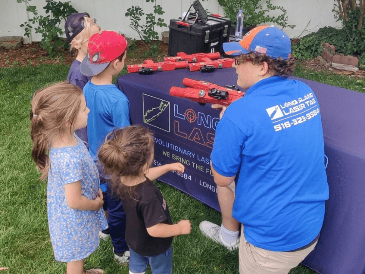 agroup of 4 children being shown how to play laser tag by a staff member from the company long island laser tag