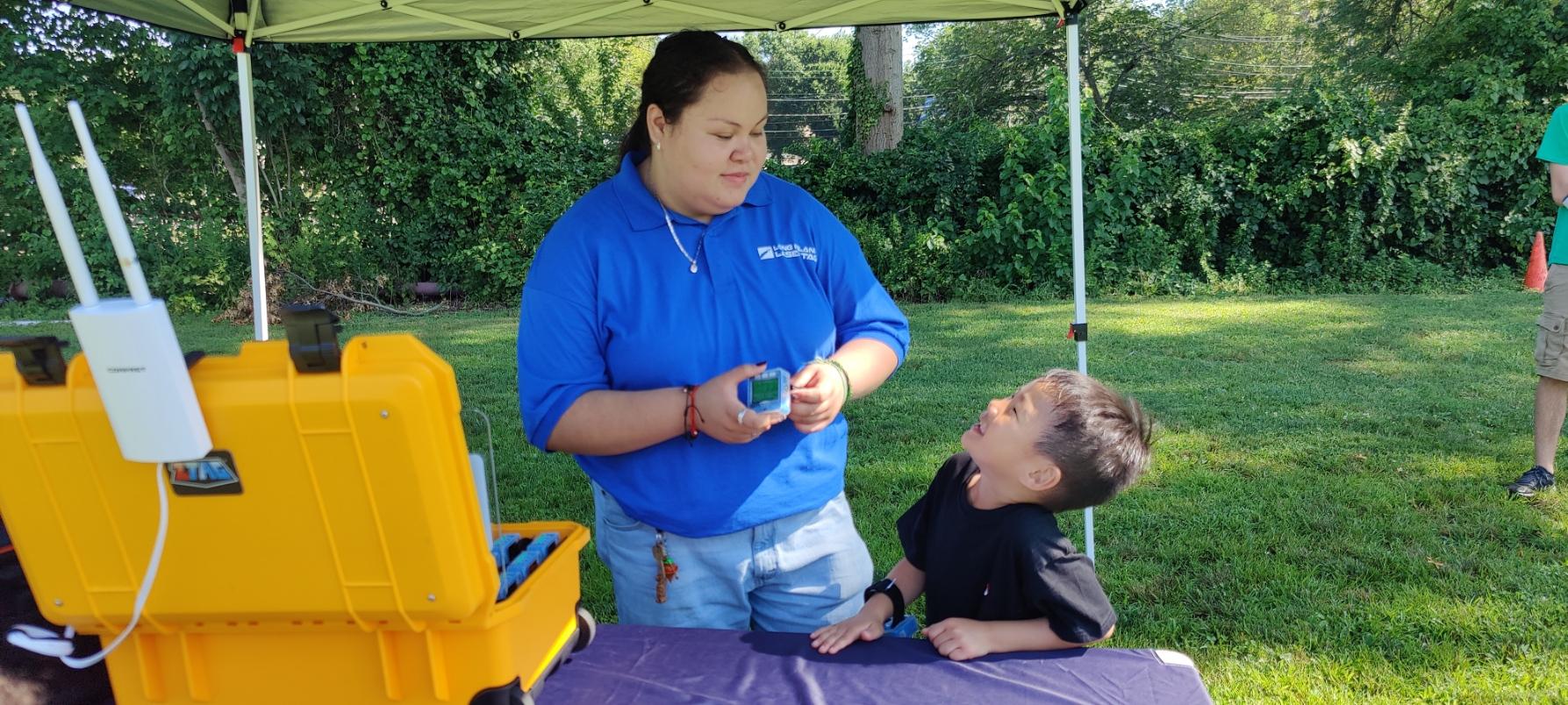 A Laser tag staff member looking at a child who is smiling back