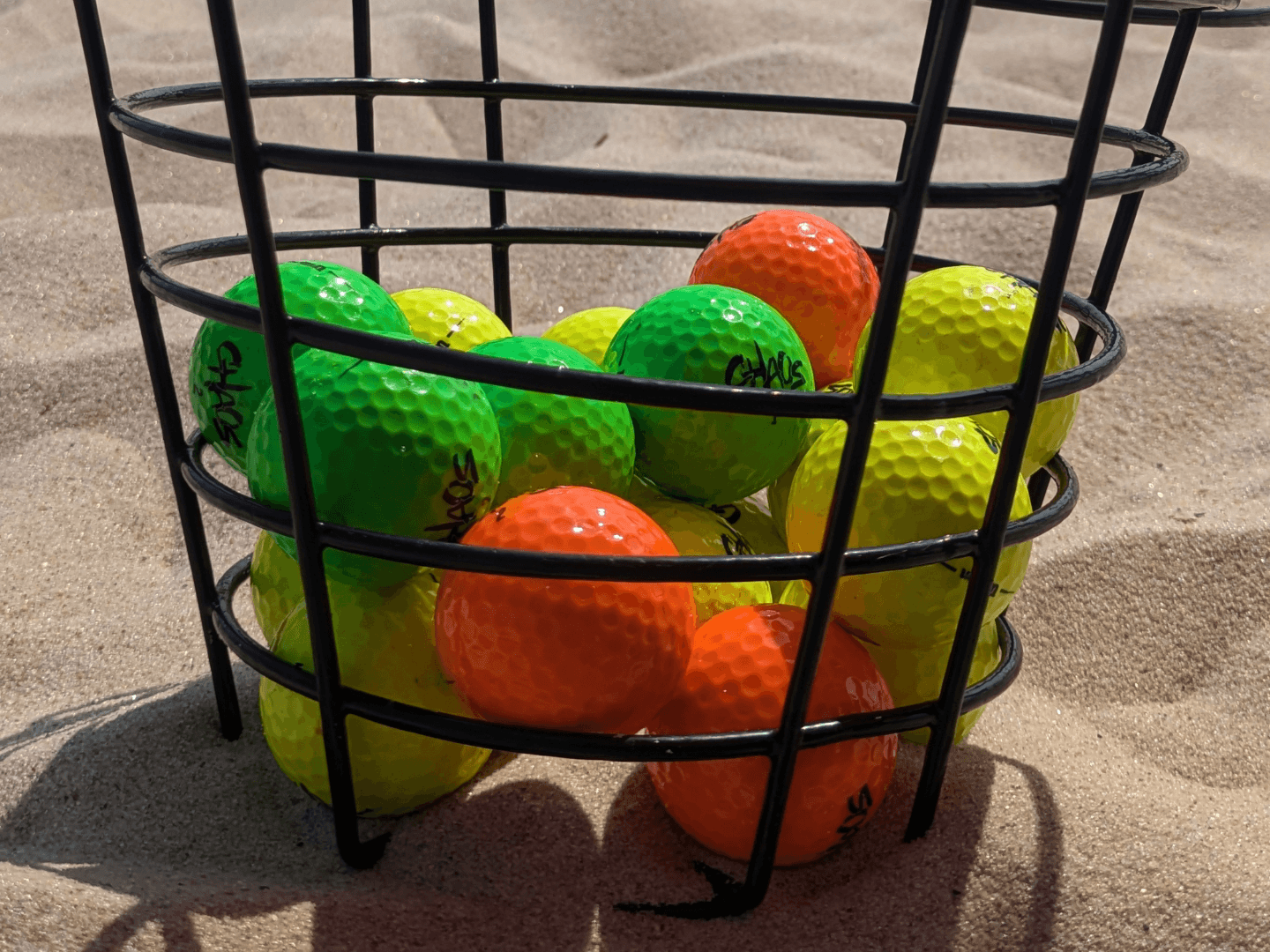 a bucket of mini golf balls and mini golf putters for long island mini golf